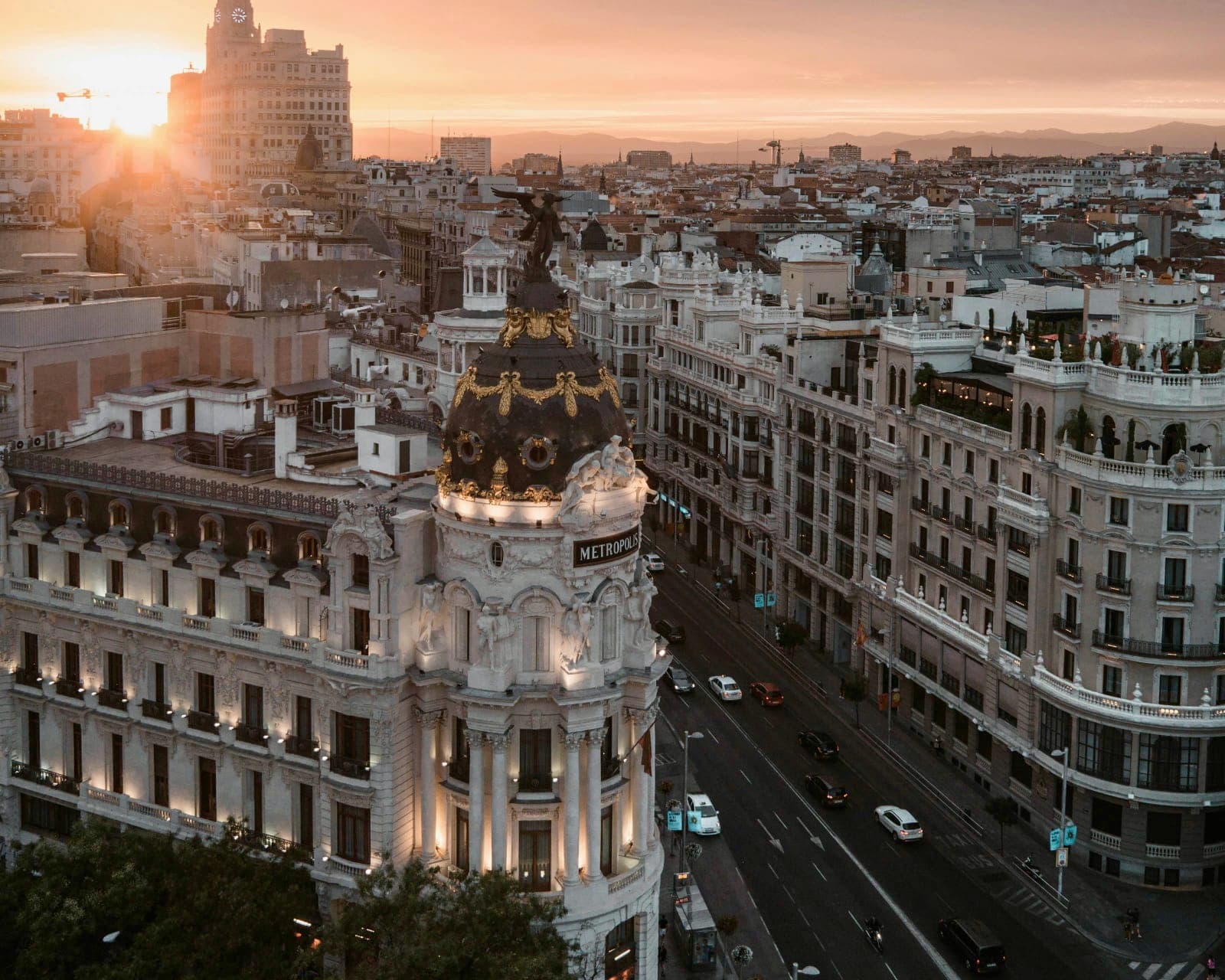 white buildings and black roofs with the sun setting in the background