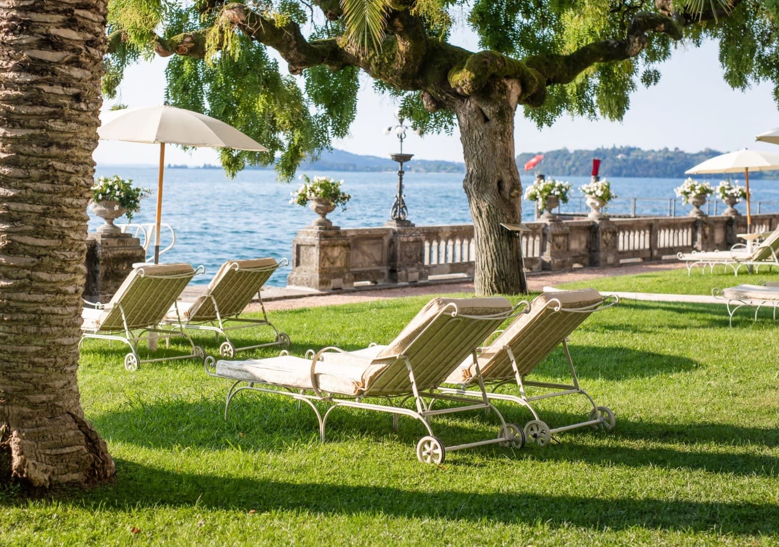 loungers on a green lawn with a lake view